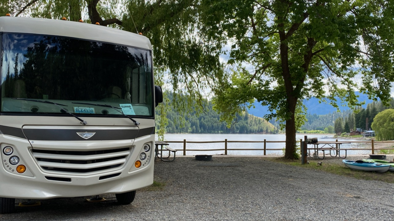 An RV parked in a scenic mountain landscape at sunset